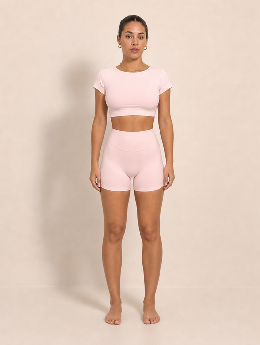 The Halo Set in Dawn Rose, front view. Short sleeve crop top and high rise short in soft pink.