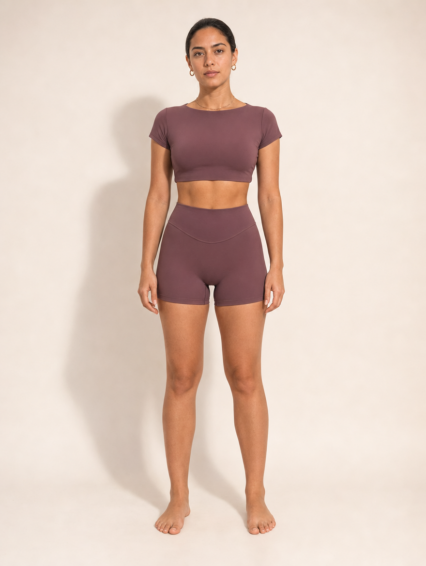 The Halo Set in Deep Umbra, front view. Short sleeve crop top and high rise short in deep plum.
